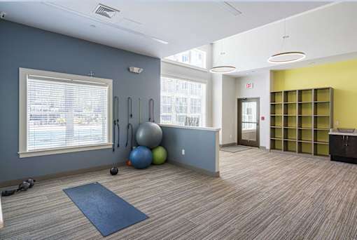 A room with a blue mat on the floor and exercise equipment at Axis at Lakeshore Apartments, Bridgewater