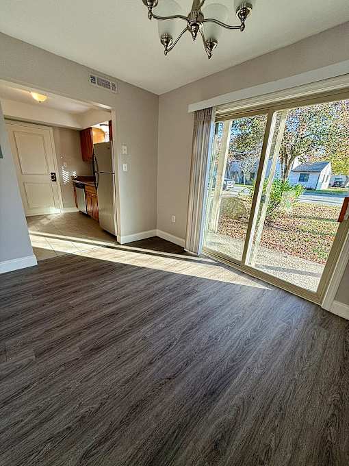 a living room with a large window and a door to a kitchen at Hidden Brook Apartment Homes Apartments, New Bedford
