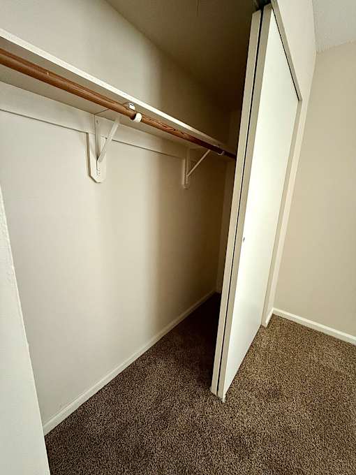 a walk in closet in a basement with a sliding door at Hidden Brook Apartment Homes Apartments, Massachusetts, 02740