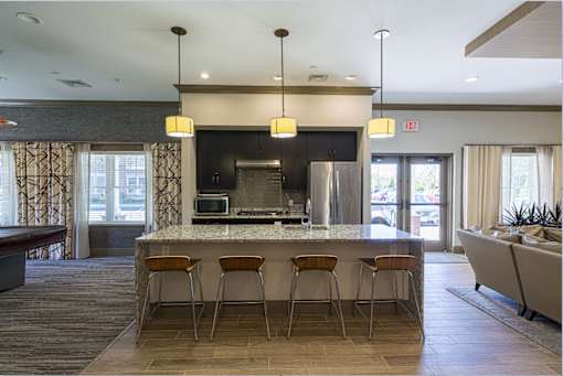 A kitchen with a bar and chairs at Axis at Lakeshore Apartments, MA,02324