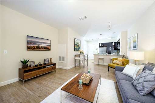 A living room with a grey couch and a wooden coffee table at Axis at Lakeshore Apartments, MA,02324