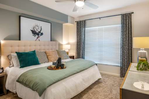 A bedroom with a bed, nightstand, and window.