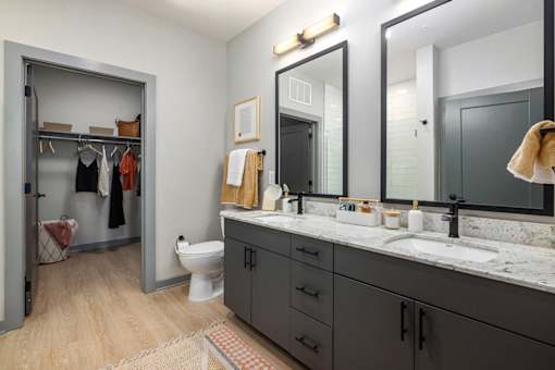 a bathroom with two mirrors and a sink and a toilet