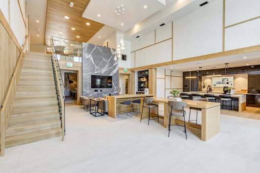 a living room with a staircase and a table with chairs