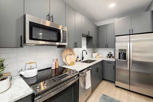a modern kitchen with stainless steel appliances and black counter tops