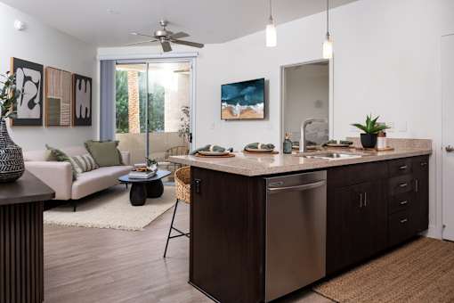 A modern kitchen with dark wood cabinets and stainless steel appliances.