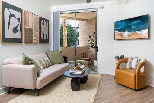 A living room with a couch, chair, and artwork on the wall.