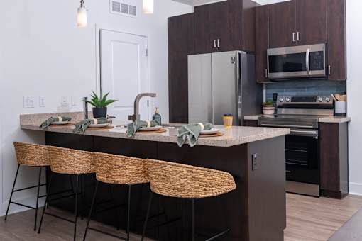 A kitchen with a counter and chairs.