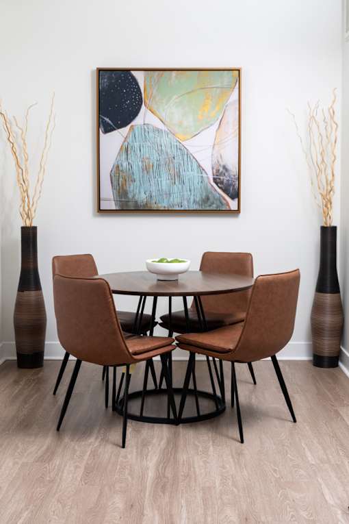 A modern dining room with a round table and chairs.