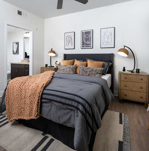A bedroom with a large bed and a ceiling fan.