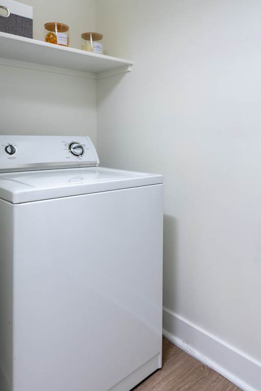 A white dryer is sitting in a laundry room.