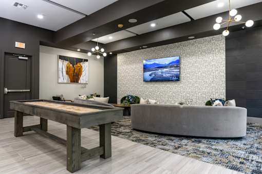 A modern living room with a wooden table and a grey sofa.