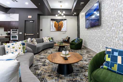 A living room with a grey couch, a green armchair, and a wooden coffee table.