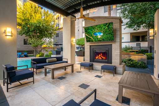 A patio with a fireplace and seating area.