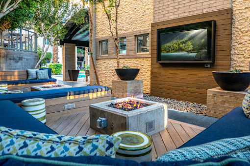 A modern outdoor living space with a fire pit and seating area.