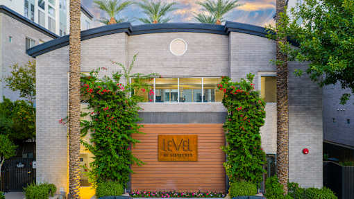 A modern building with a wooden entrance and a sign that reads "LEVEL".