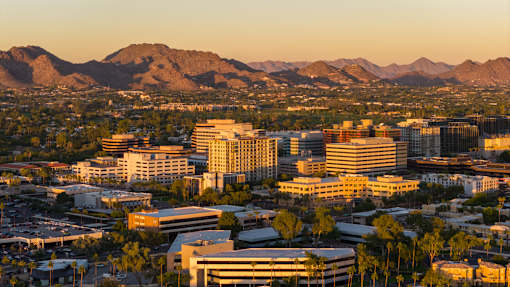 A cityscape with buildings and mountains in the background.
