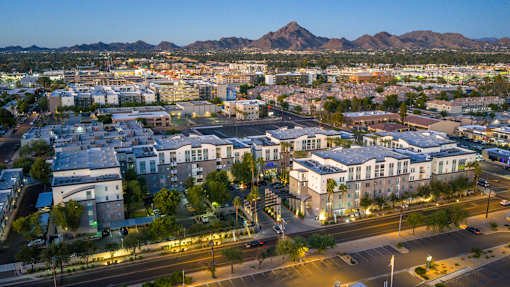 A cityscape with buildings and a mountain in the background.