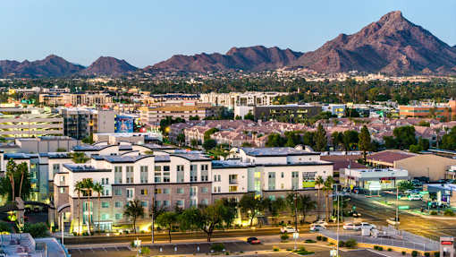 A cityscape with buildings and a mountain in the background.