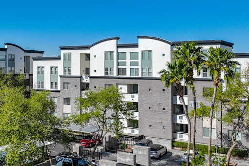 A modern apartment complex with a parking lot in front.