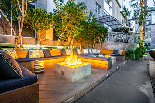 A modern outdoor seating area with a fire pit in the center.