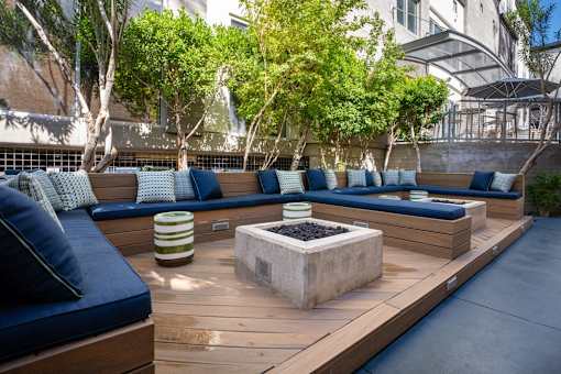 A modern outdoor seating area with blue cushions and wooden benches.