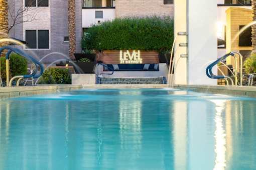 A pool with a slide and a building that says "LEVEL" in the background.