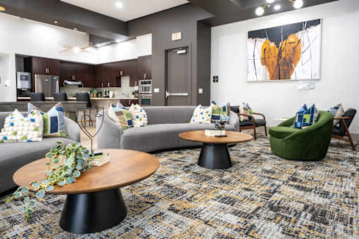 A modern living room with a grey sofa, a green armchair, and a wooden coffee table.