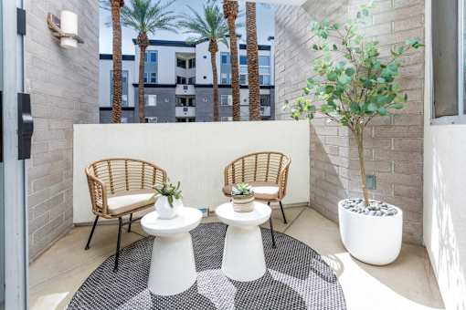 A patio with two chairs and two tables.