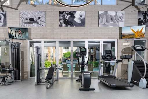 A gym with treadmills, exercise bikes, and other equipment.
