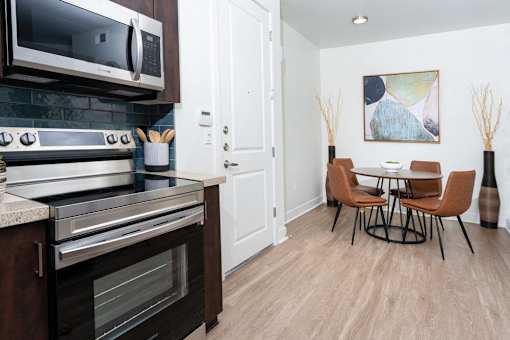 A modern kitchen with a dining table and chairs.