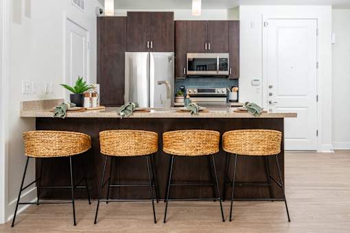 A kitchen with a bar stool and a counter.