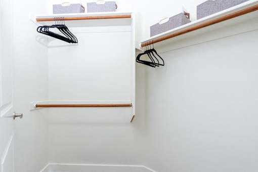 A white closet with a black hanger and a white door.