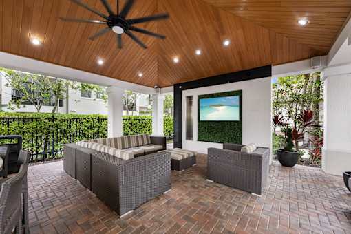 A patio with a ceiling fan and a couch.