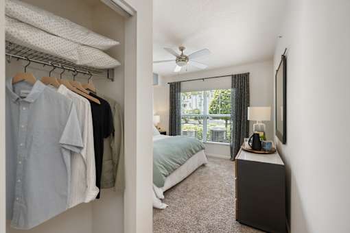A bedroom with a bed, a dresser, and a window with curtains.