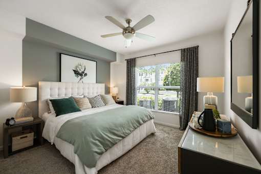 A bedroom with a large bed and a ceiling fan.
