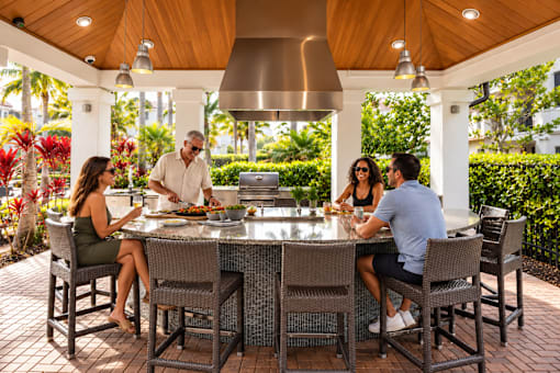 Four people are sitting around a table eating.
