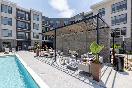 an outdoor patio with chairs and a swimming pool
