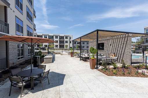 an outdoor patio with tables and umbrellas at the preserve at polk apartments