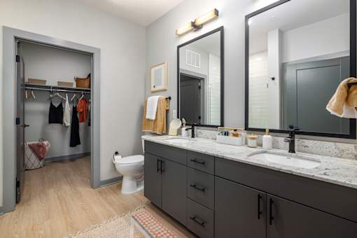 a bathroom with two mirrors and a sink and a toilet