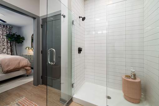 a white bathroom with a shower and a bed