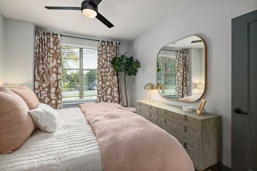 a bedroom with a bed and a mirror and a window