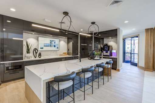 a large kitchen with a marble counter top and bar stools