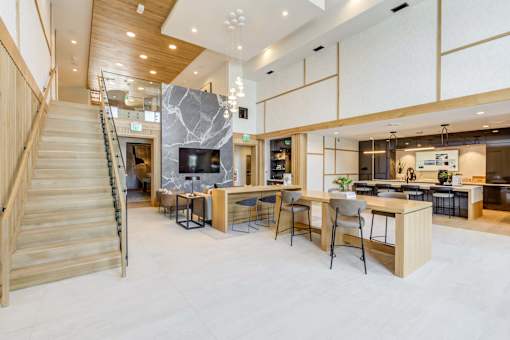 a living room with a staircase and a table with chairs