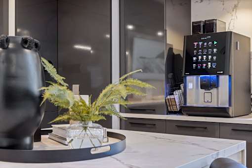 a kitchen counter with a coffee machine and a vase on it