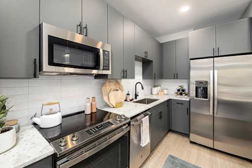 a modern kitchen with stainless steel appliances and black counter tops