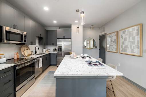 a kitchen with a marble counter top and stainless steel appliances