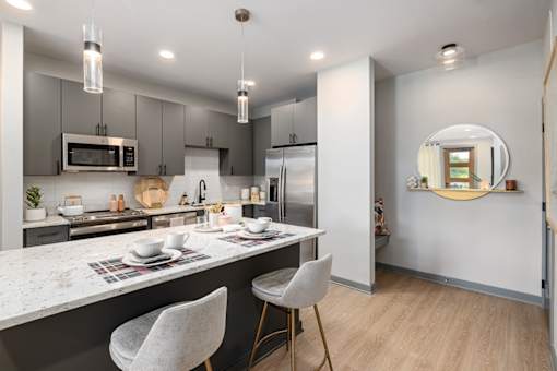 a kitchen with a marble counter top and a stainless steel refrigerator
