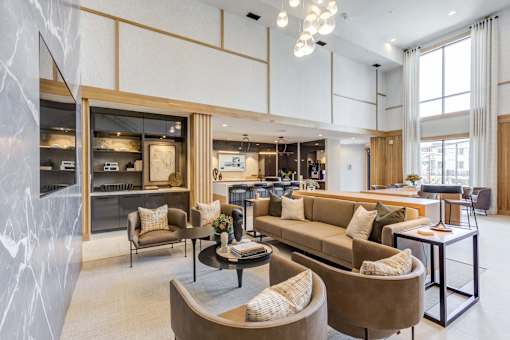 a living room with couches and chairs and a kitchen