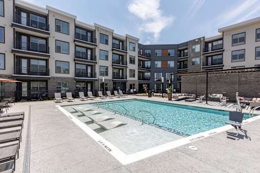 an apartment swimming pool in front of an apartment building